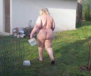 Thick farmer is feeding the chickens in her naked